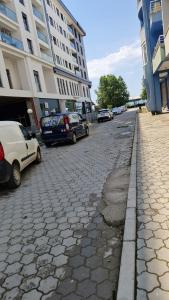 a cobblestone street with cars parked next to a building at Orges Apartament in Struga