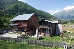 a wooden house with a fence in front of it at Cottage Mildiani in Mestia