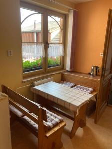 a table and bench in a room with a window at Penzion Kohout in Nýrsko