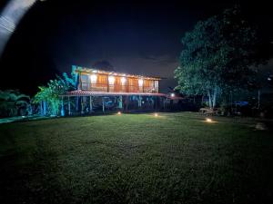 a house lit up at night with a grass yard at Villa Mara in Filandia +17 photos