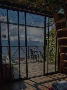 eine überdachte Veranda mit Blick auf das Wasser in der Unterkunft NatuGlamp in Medellín