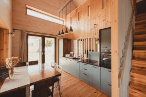 a kitchen with wooden walls and a table with chairs at gemütliches Holzhaus am See in Warin