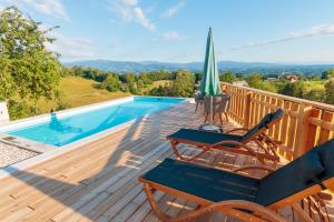 a deck with chairs and an umbrella and a swimming pool at Ferienhaus Sterzhansl in Pongratzen