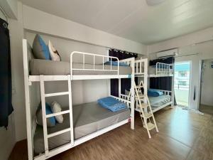 a room with three bunk beds and a ladder at Comfy hotels Suvarnabhumi in Suvarnabhumi Airport