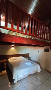 a bedroom with a large bed with a wooden at Pousada Beco da Lua in Olímpia +114 photos