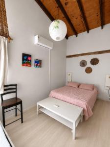 a white bedroom with a bed and a table at Nao Tem Fim in Punta Del Diablo +99 photos