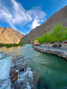 a river with mountains in the background at Saleem Resort in Skardu
