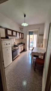a kitchen with a table and a white refrigerator at Appartamento in Via Cardella in Pitigliano