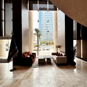 a living room with couches and a large window at Park Elite Hotel - فندق بارك إيليت in Mecca
