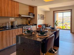 a kitchen with a table with bowls and plates on it at Loft en Zibata con Vista Alberca y Gym in La Cañada