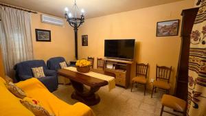 a living room with a couch and a television at LA FUENTE ROMANA in Campo-Nubes