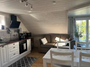 a kitchen and living room with a couch and a table at Solhem Terrassen in Arvika