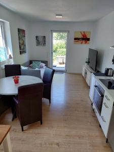 a kitchen and a living room with a table and a couch at Villa Bianca - Holiday & Business in Elsenfeld