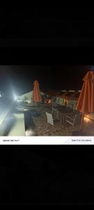 a group of chairs and umbrellas on a beach at night at Lions adventure in Narok