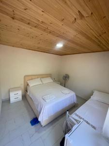 a bedroom with two beds and a wooden ceiling at Bujtina Dalmacia 2 in Shkodër