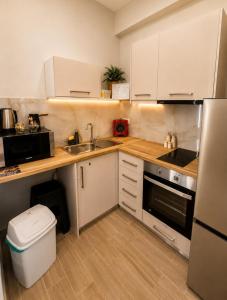 a small kitchen with white cabinets and a sink at Galazio suites 3 Seaside in Salamina