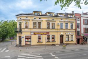 a yellow building on the corner of a street at The Lion Rooms -Apartamenty z aneksami kuchennymi in Ustroń