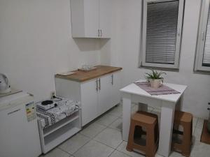 a small kitchen with a table and a white refrigerator at Charshija in Struga