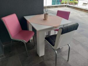 a table with two pink chairs and a white table with aitating at Charshija in Struga