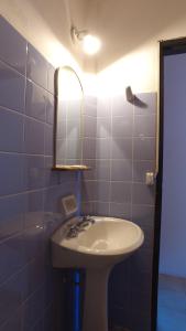 a bathroom with a sink and a mirror at Hosteria Nilo Azul in Mina Clavero