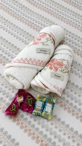 two towels and some candy on a bed at Studio Moderno e Aconchegante , Centro Unai in Unaí
