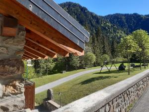 eine Steinmauer neben einem Feld mit einer Straße in der Unterkunft Chalet Laghetti in Schilpario