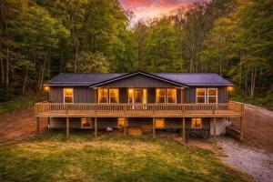 a house with a large deck in the woods at 5BR Hocking Hills Cabin, Arcade, Forest Views in South Bloomingville