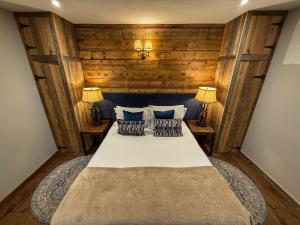 a bedroom with a large bed with two lamps at Black Diamond Sainte Foy Chalets in Sainte-Foy-Tarentaise