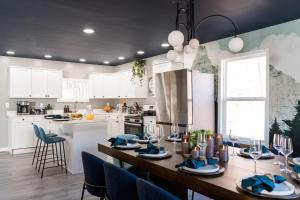 a kitchen with a wooden table and blue chairs at 5BR Hocking Hills Cabin, Arcade, Forest Views in South Bloomingville