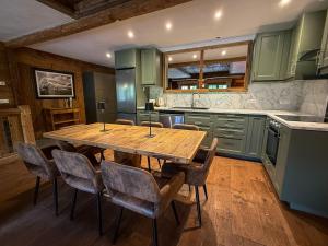 a kitchen with a wooden table and chairs at Black Diamond Sainte Foy Chalets in Sainte-Foy-Tarentaise