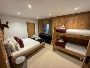 a bedroom with two bunk beds and a window at Black Diamond Sainte Foy Chalets in Sainte-Foy-Tarentaise