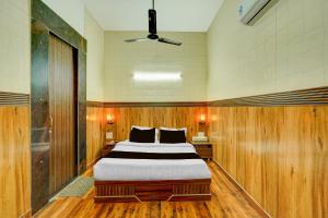 a bedroom with a large bed with wooden walls at HOTEL O SAFFRON in Meerut