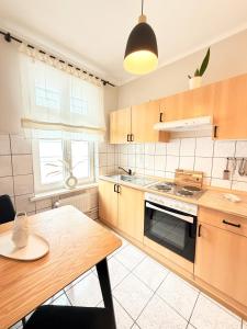 a kitchen with wooden cabinets and a wooden table at Villa Victoria in Binz