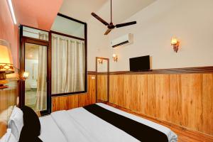 a bedroom with a bed and a flat screen tv at HOTEL O SAFFRON in Meerut