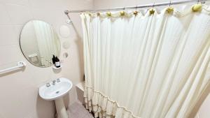a bathroom with a shower curtain and a sink at AltaMar in Playa Unión +9 photos