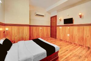 a bedroom with a bed and a flat screen tv at HOTEL O SAFFRON in Meerut