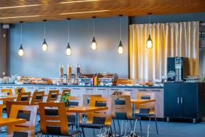 a restaurant with tables and chairs and a counter at Hotel Ledňáček in Ostrava