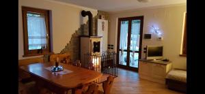 ein Wohnzimmer mit einem Holztisch und einem Kamin in der Unterkunft Chalet Laghetti in Schilpario