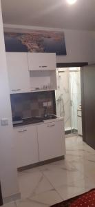 a kitchen with white cabinets and a sink at Private small studio in Qrendi