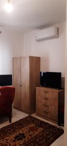 a living room with a tv and a wooden cabinet at Private small studio in Qrendi