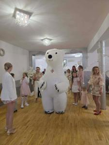 a large stuffed polar bear standing in a room with children at Sister's House Zator in Zator