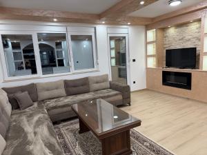 a living room with a couch and a tv at Lux apartment in Dobra Voda
