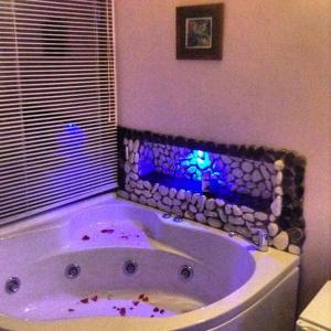 een paars bad in een badkamer met een rotswand bij Mola Hotel in Marmara Adasi