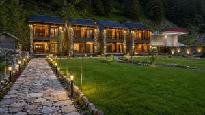 a large house with lights on a lawn at night at Lavender Resort Naran in Naran