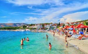 a beach with a bunch of people in the water at apartmenttwelve in Trogir