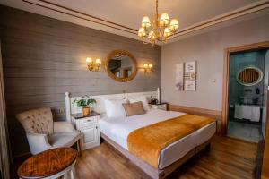 a bedroom with a bed and a chair and a mirror at My Dora Hotel in Istanbul
