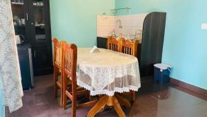 a dining room table with chairs and a kitchen at Coorg Annu Stay in Madikeri