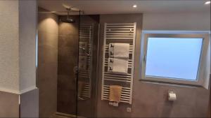 a bathroom with a shower and a window with towels at Apart Ritzl in Fügen