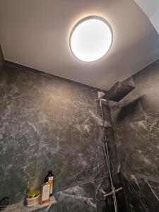 a bathroom with a shower and a round light on the ceiling at Moon Love in Pakopi +39 photos