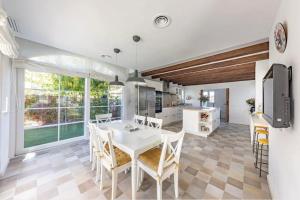 a kitchen and dining room with a white table and chairs at Villa entre Viñas in Lavid